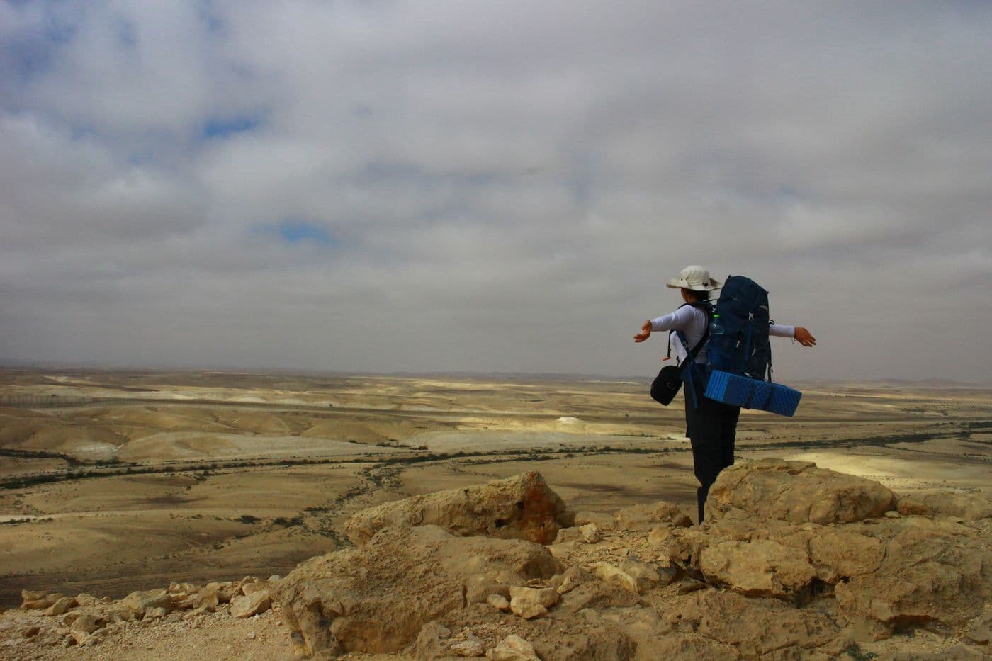 A participant with a pack spreading their arms out towards the view