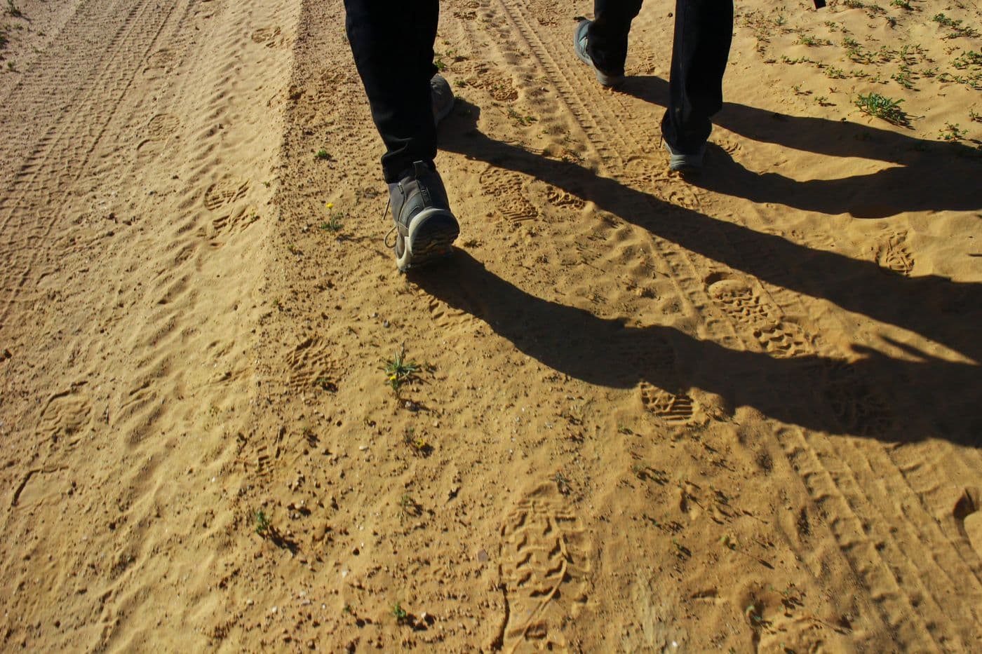 Feet walking a dirt road — one step after another