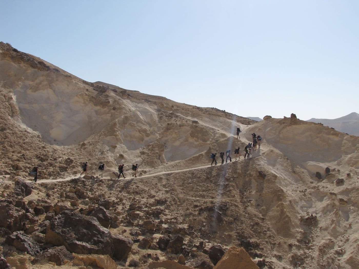 משתתפים הולכים בטור על רכס מדברי